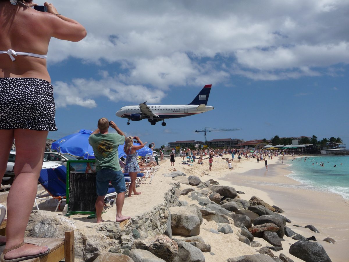 Tourists on Maho Beach, St. Maarten, watching aircraft land just overhead at Princess Juliana Airport